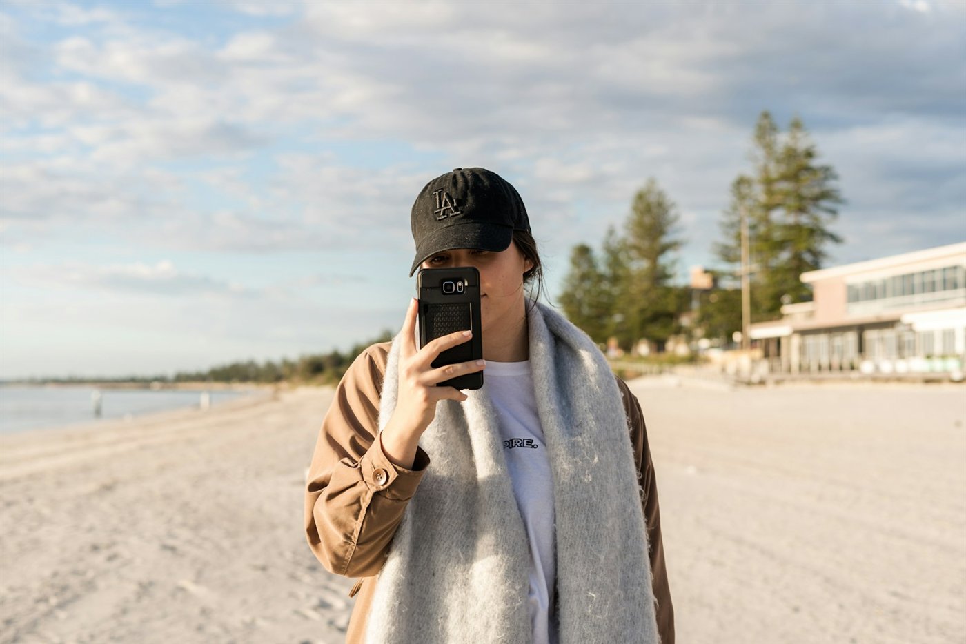 A guest checking the Driftwood dashboard on a phone at the beach